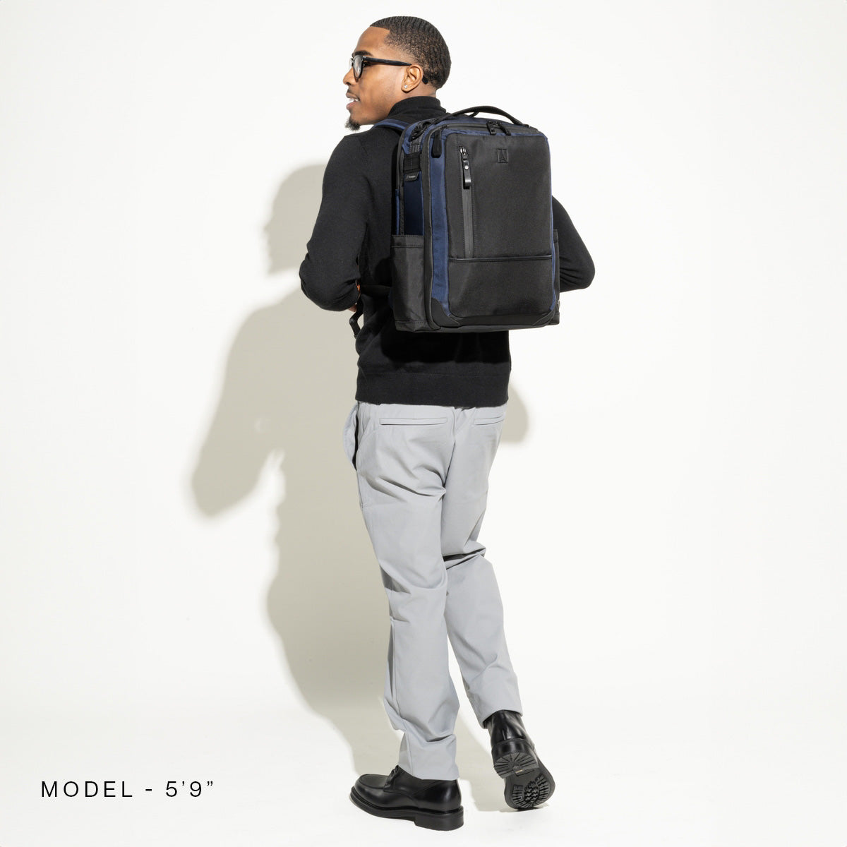 Person wearing a black backpack on a white background
