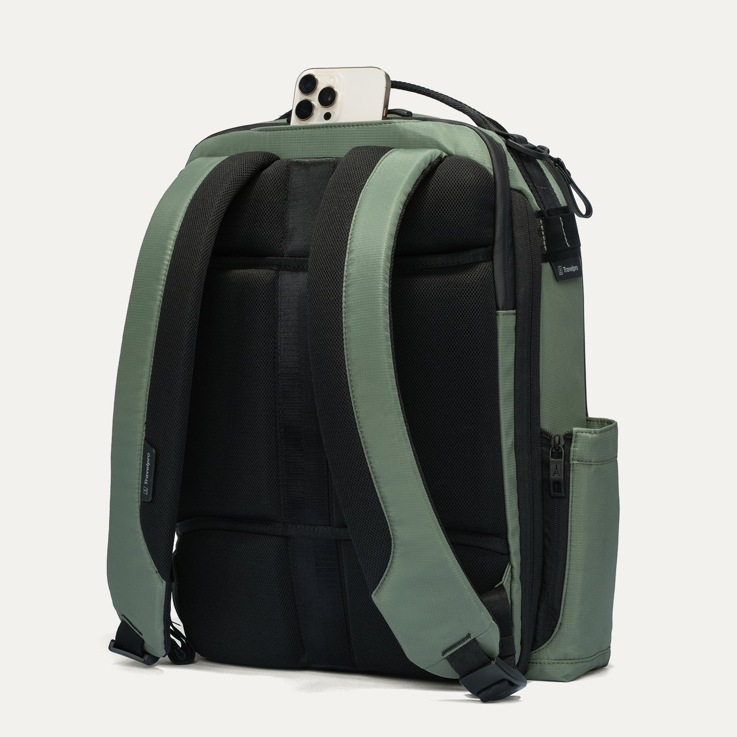 Green and black backpack with a phone on top against a white background