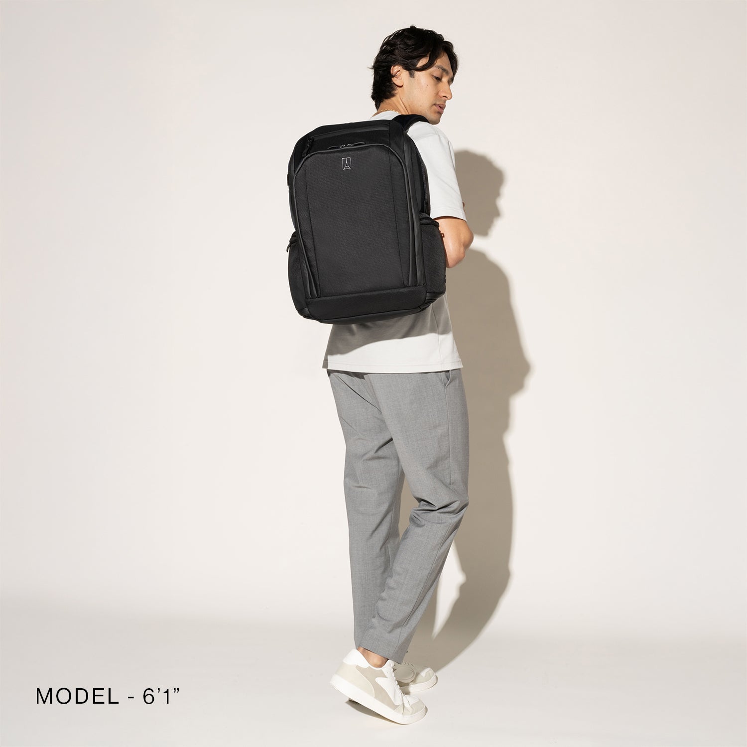 Person wearing a black backpack on a white background