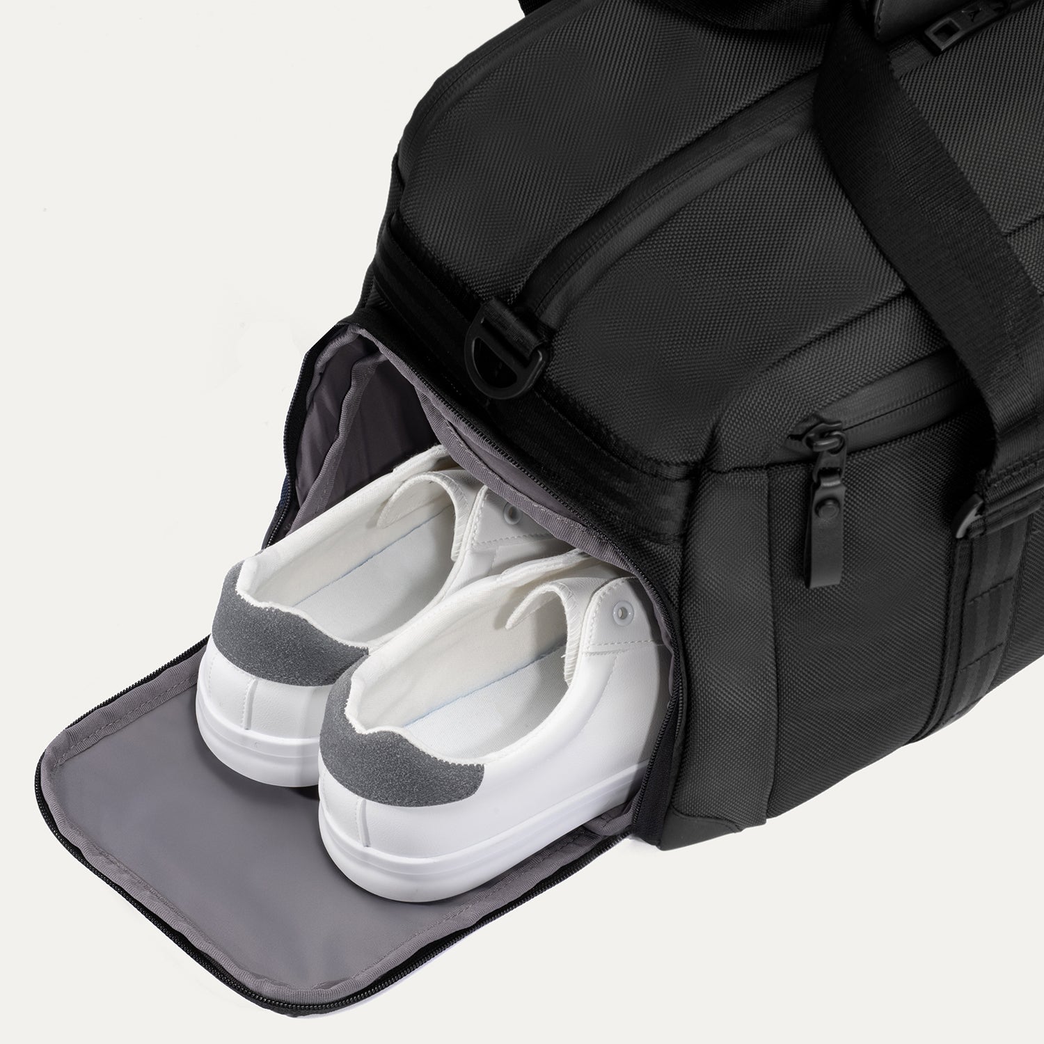 Travelpro Altitude Day-to-Day Duffel in Jet Black, showing open side compartment with shoes stored inside.
