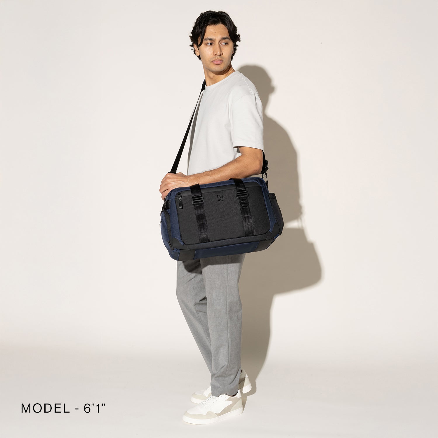 Person wearing a aviator navy duffel over the shoulder on a white background