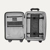 Open interior view of the Optima Expandable Compact Carry-on Spinner in Black, showcasing the organized packing system with a built-in compression panel, zippered divider, accessory pockets, and ECOFAB™ interior lining.