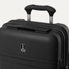 Close-up detail view of the Optima Expandable Compact Carry-on Spinner in Black, showcasing the ergonomic top carry handle and the centered Travelpro logo on the durable hardshell exterior.