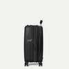 Side-profile view of the Optima Expandable Compact Carry-on Spinner in Black, highlighting the integrated TSA-compliant lock, secure zipper closure, and expandable design for added packing capacity.