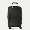 Rear view of the Optima Expandable Medium Check-in Spinner in Black, showcasing the adjustable PowerScope extension handle and the sleek, ribbed hardside exterior.