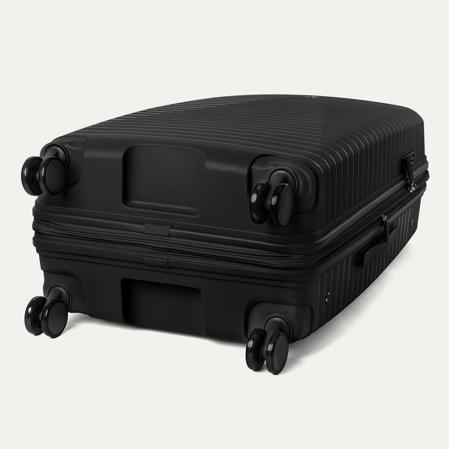 Underside view of the Optima Expandable Large Check-in Spinner in Black, showcasing the durable base and self-aligning PrecisionGlide spinner wheels designed for smooth, effortless mobility.