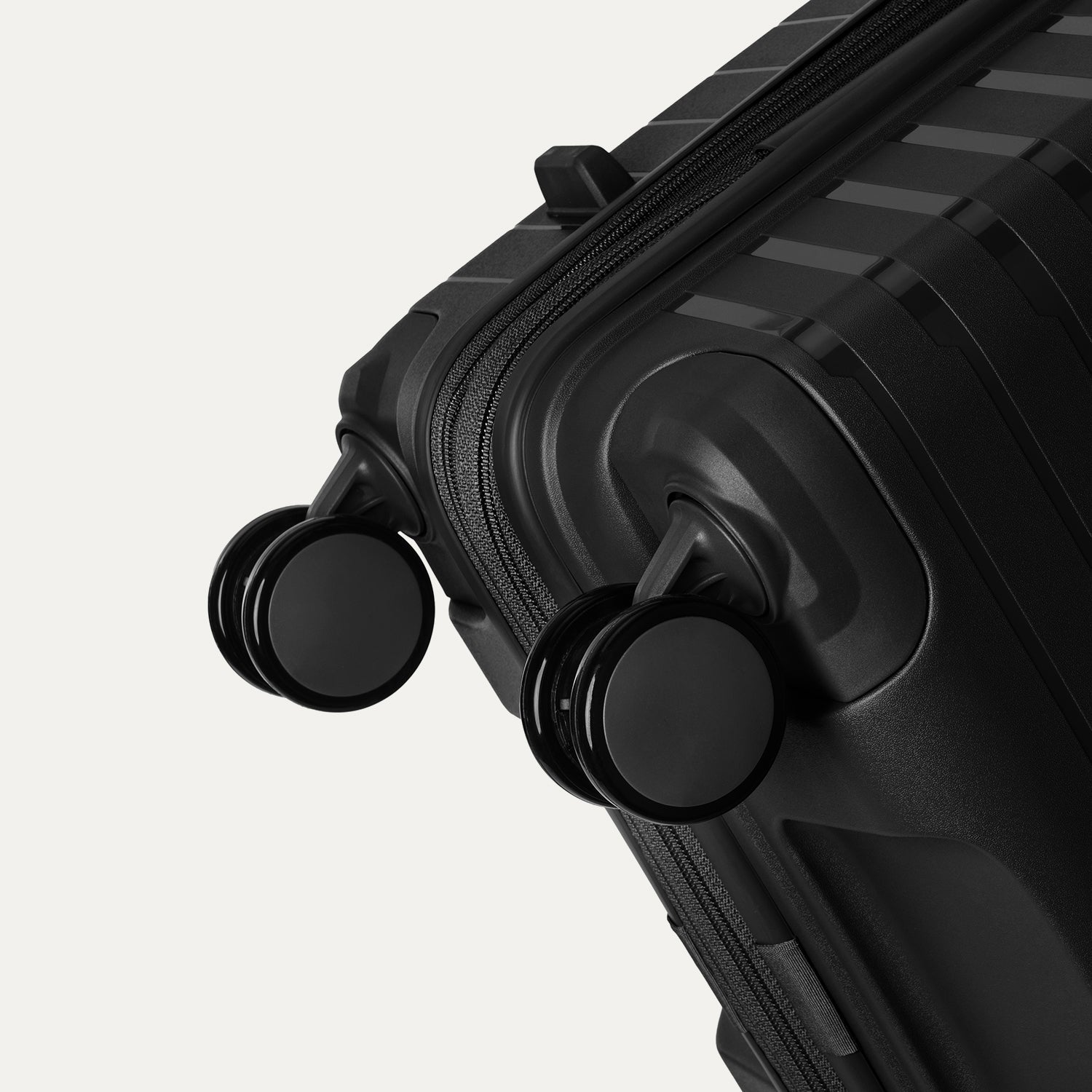 Close-up detail view of the self-aligning spinner wheels on the Optima Expandable Large Check-in Spinner in Black, highlighting the durable, smooth-rolling construction.