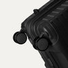 Close-up detail view of the self-aligning spinner wheels on the Optima Expandable Large Check-in Spinner in Black, highlighting the durable, smooth-rolling construction.